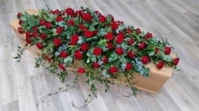 Classic red rose flower and foliage double ended funeral coffin spray with trails of soft ruscus and ivy