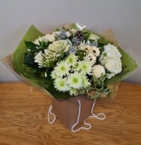 festive white chistmas flower handtied bouquet in a gift bag